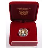A GHANIAN 500 SIKA 9 CARAT GOLD AND ENAMELLED COMMONWEALTH TRIBUTE COIN, boxed