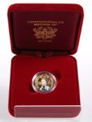 A GHANIAN 500 SIKA 9 CARAT GOLD AND ENAMELLED COMMONWEALTH TRIBUTE COIN, boxed