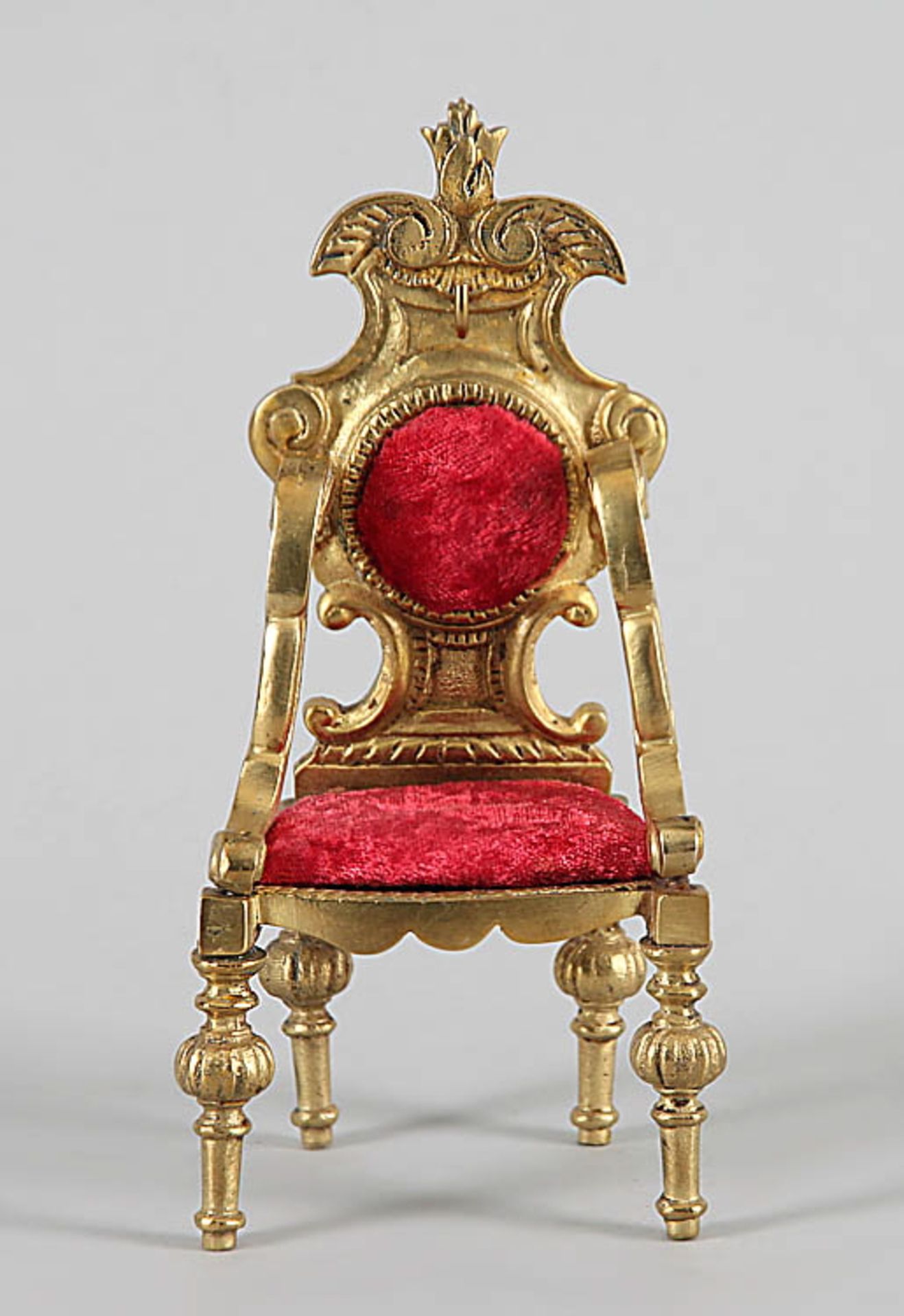 TaschenuhrständerForm eines barocken Armlehnstuhls. Messingguss, roter Samtbezug. H 15,5 cm.€ 20