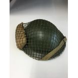 WWII Style British Tommy helmet with cam net and field dressing.