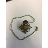 O.B.E. gilt silver and enamelled Dames brooch on 9ct gold chain.