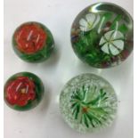 Four vintage paperweights, three with flowers one with fish and frog.