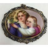 Painted large brooch of two children in silver filigree surround.