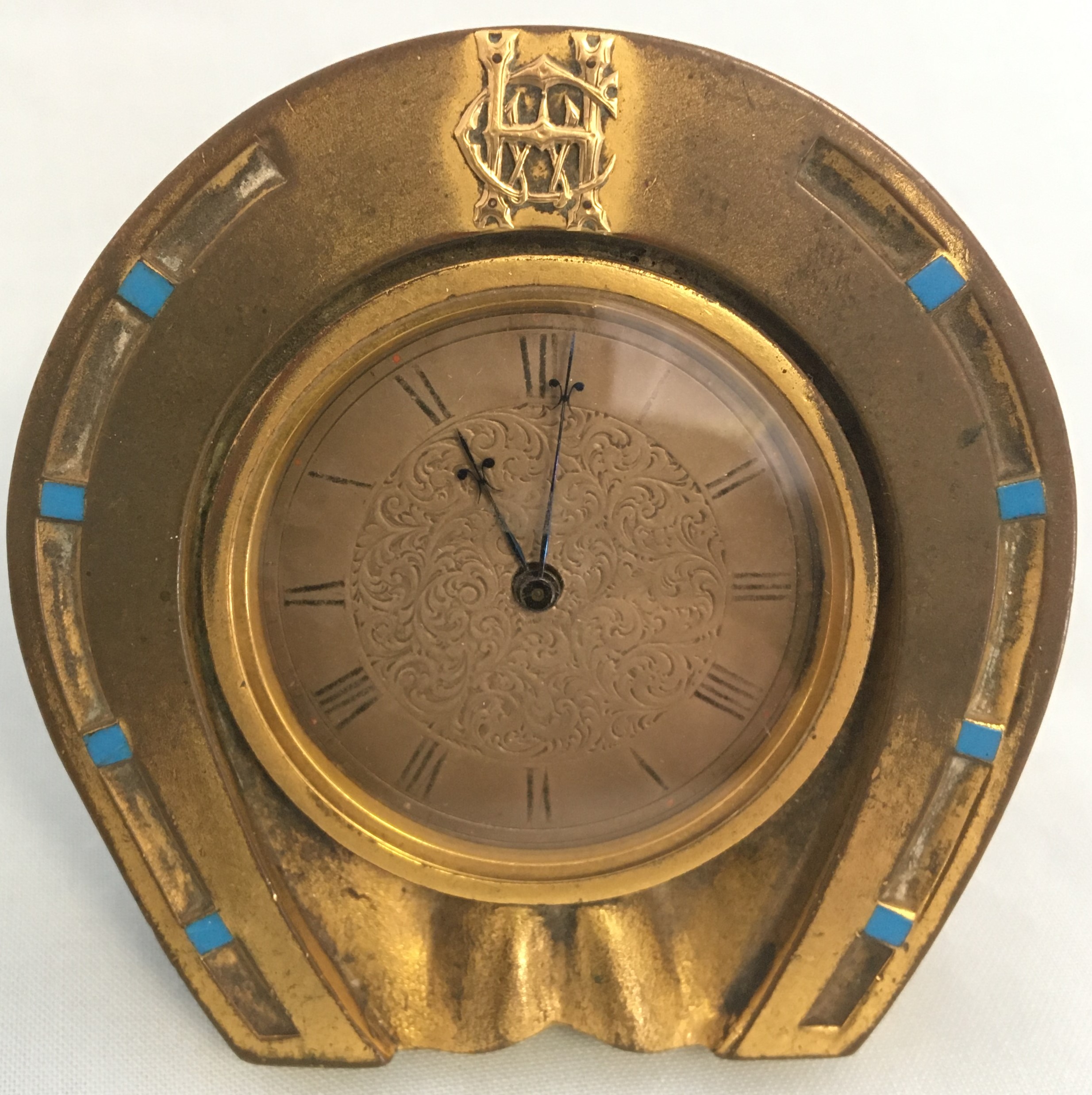 Jenner & Knewstub Horse shoe strut Clock, with enamel and monogram.