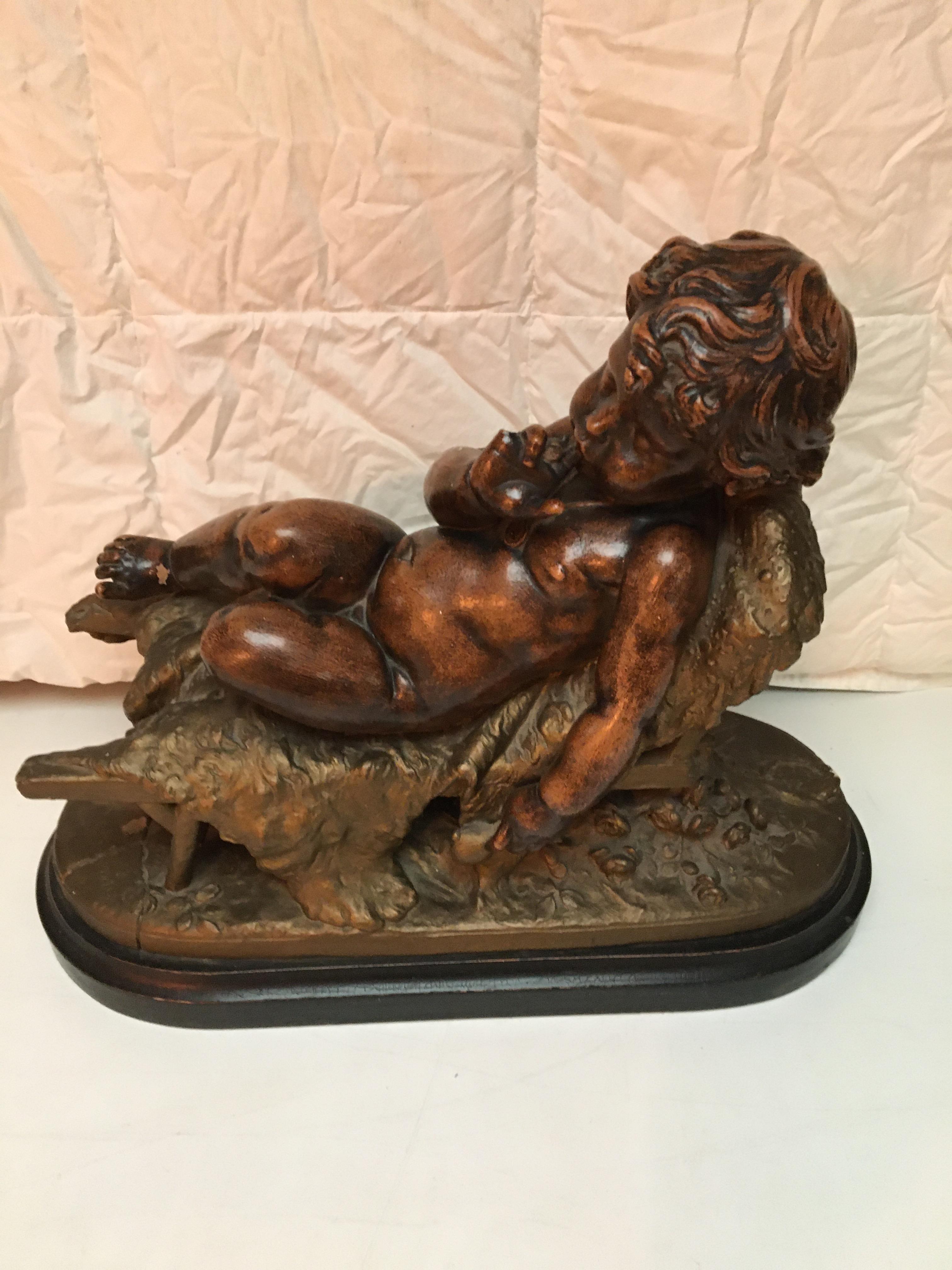 19th C Terracotta figure of a putti sleeping on a chair.