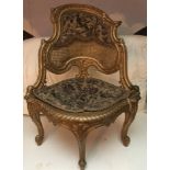 Ornate gilt embroidered rattan backed corner seat.