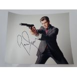 AUTOGRAPHS: JAMES BOND: PIERCE BROSNAN - signed action photo - has been independently verified and