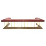 Late 20th century club fender, red studded faux leather upholstered seat raised on reeded brass