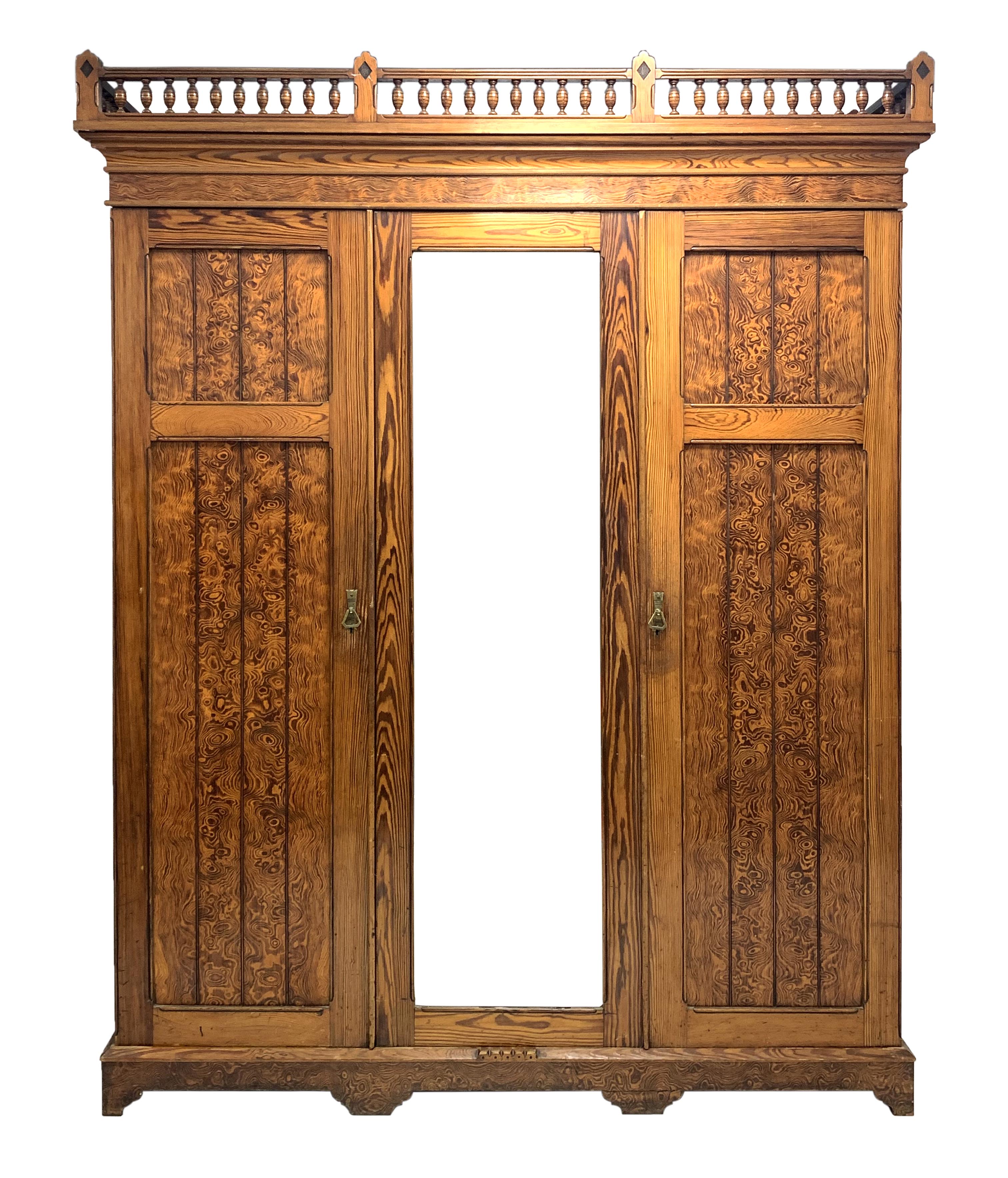 Late Victorian pitch pine triple wardrobe, turned gallery pediment over projecting cornice,