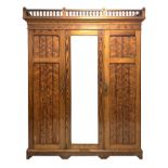 Late Victorian pitch pine triple wardrobe, turned gallery pediment over projecting cornice,