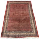 Large Persian Araak carpet, red ground field decorated all over with Boteh motifs, multiple band