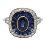 Platinum sapphire and diamond ring, the central oval sapphire surrounded by halo of calibre cut