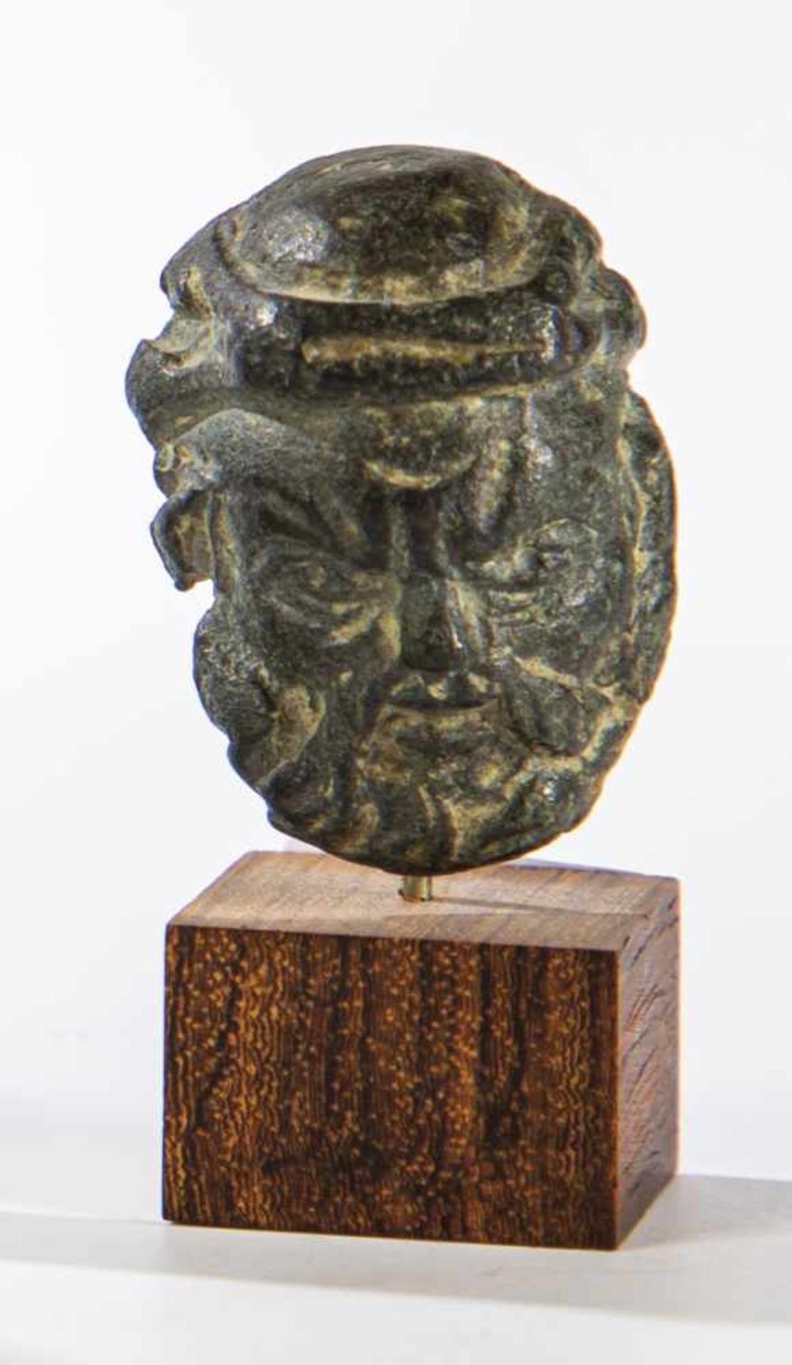 Head of a bearded man. Probably Etruscan 5th century BC. Bronze on a wooden base. 3 cmhigh.Kopf