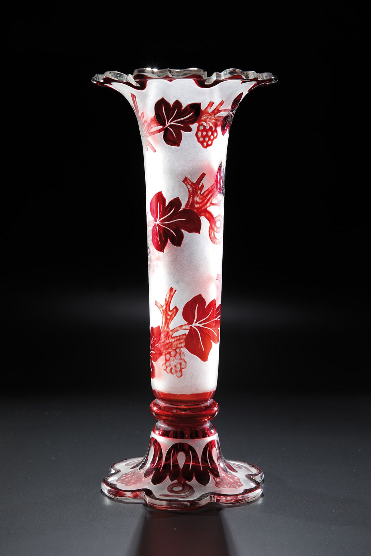 Vase mit TraubengirlandeBöhmen, 2. H. 19. Jh. Farbloses Glas mit rotem Überfang, durchschliffen,