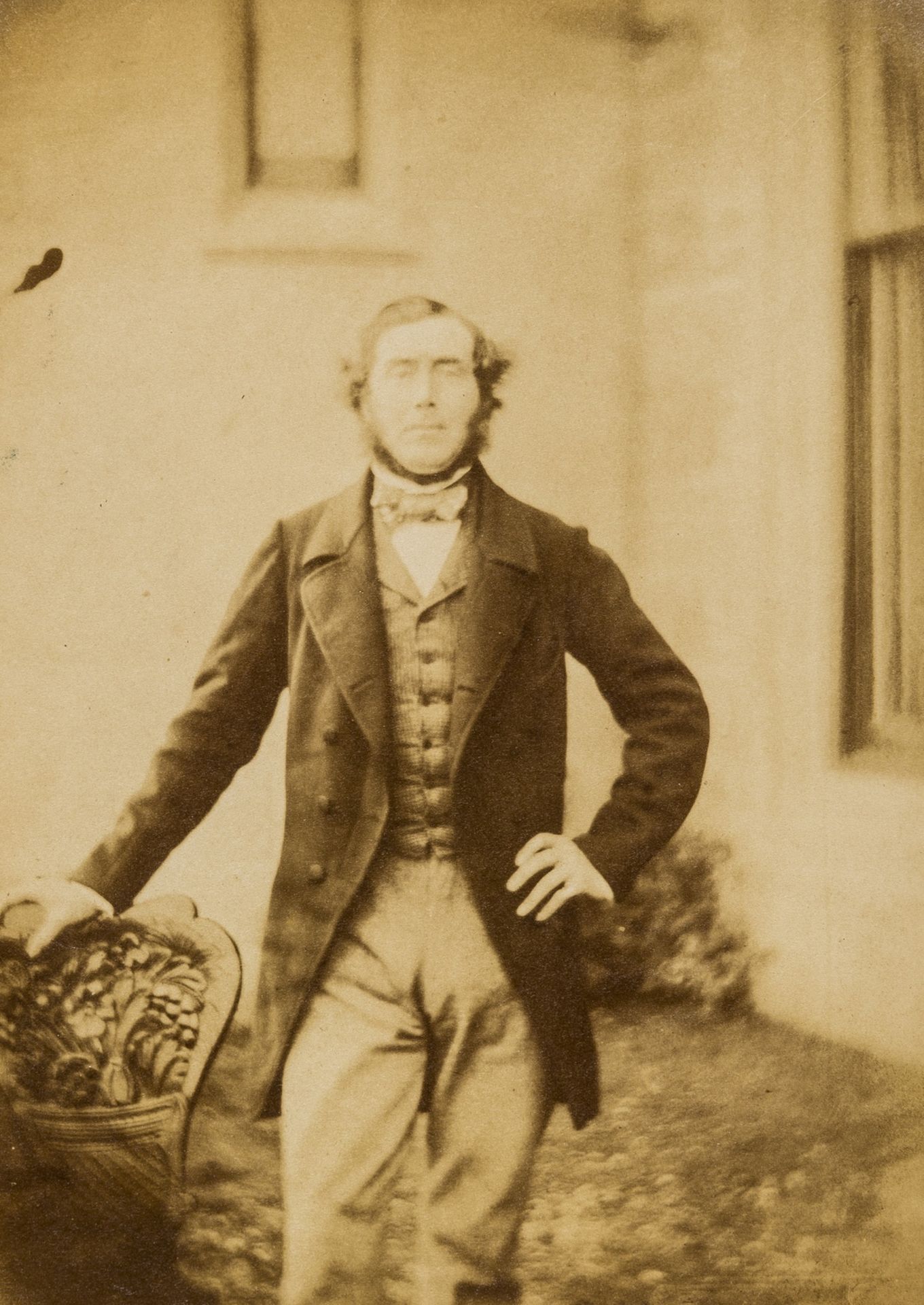 Photographs.- Man standing on steps in front of arched doorway with spaniel, ?salt print, [1850s] …