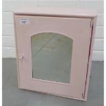 Vintage painted pink metal bathroom cabinet with a glazed door