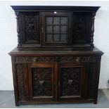 Carved oak dresser with a glazed door flanked by turned uprights, over two frieze drawers and pair