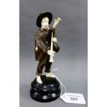Bone and carved wooden figure of a Piper on a circular ebonised plinth base, 16.5cm high