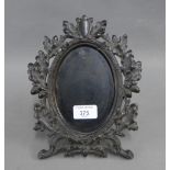 Acorn leaf ebonised wooden frame with a metal strut back, 24cm high