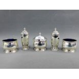 George V silver four piece condiment set comprising a pair of pepper pots, two salts and a mustard