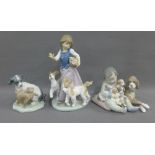 Two Lladro figures of Children with Dogs and a Nao figure of a Dog and Cat, (3)