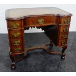 Queen Anne style mahogany dressing table / desk, the concave top with moulded edge and inset brown