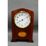 Mahogany and inlaid mantle clock, the arched top over a circular dial with Roman numerals, 20cm