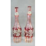 Pair of ruby flashed glass fruit and vine patterned decanters with stoppers, 33 cm high, (2)