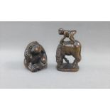 Two Japanese hardwood Netsuke to include a Monkey standing on a Horse and another of a Monkey with