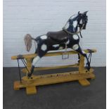 Vintage black and white rocking horse on a pine trestle base, inscribed 'Milton the wonder horse'