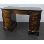 Mahogany desk with a serpentine top over an arrangement of nine drawers, 79 x 115 cm