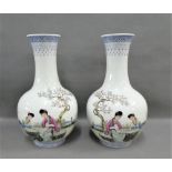 Pair of Chinese white glazed vases painted with figures in a garden with blue and white stylised