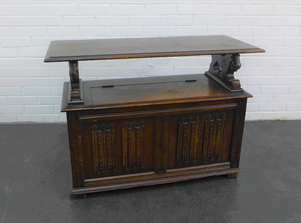 Early 20th century oak Monks bench, the rectangular top on lion arm rests with lift up compartment