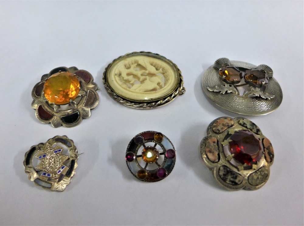 A collection of silver and white metal Scottish hardstone brooches together with a silver mounted