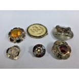 A collection of silver and white metal Scottish hardstone brooches together with a silver mounted