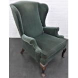 Green upholstered wing back armchair on short cabriole legs