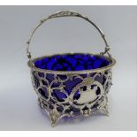 Edwardian silver sugar bowl, London 1908, with swing handle, foliate pierced sides and blue glass