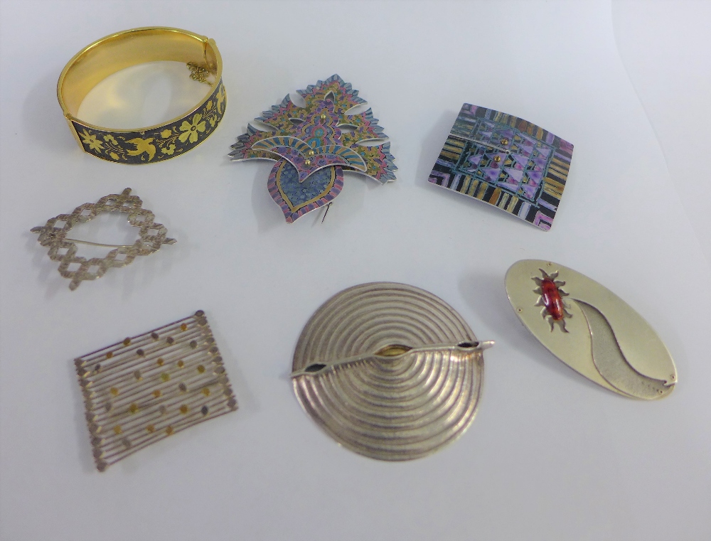 A group of five contemporary brooches to include two silver, two anodised and one white metal