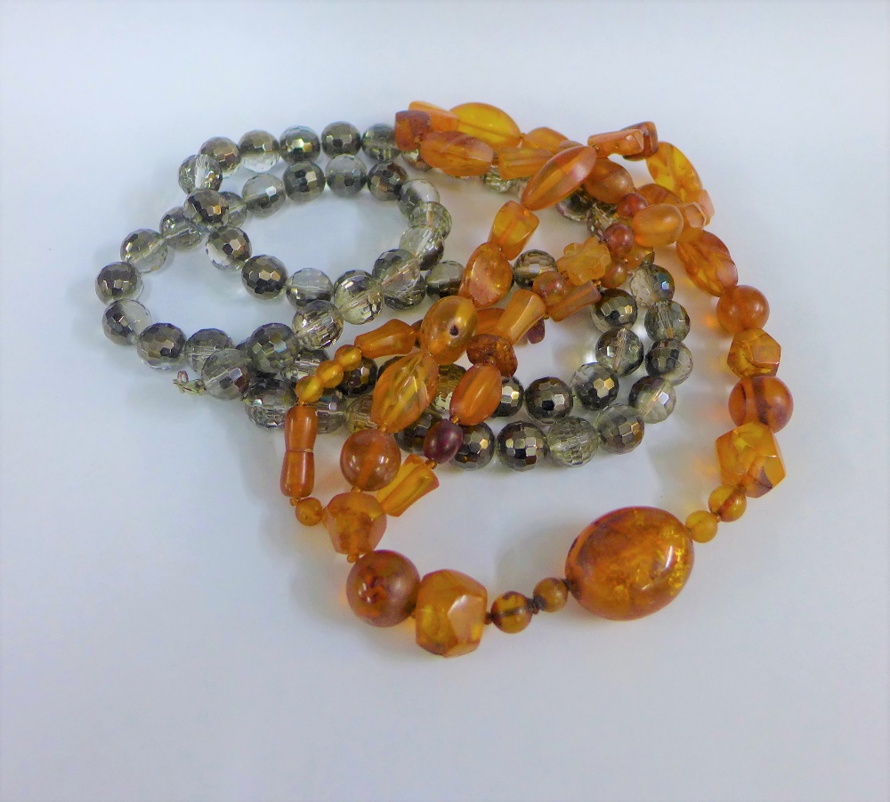 Strand of vintage amber beads with polished oval and facet beads together with a strand of crystal