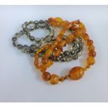 Strand of vintage amber beads with polished oval and facet beads together with a strand of crystal