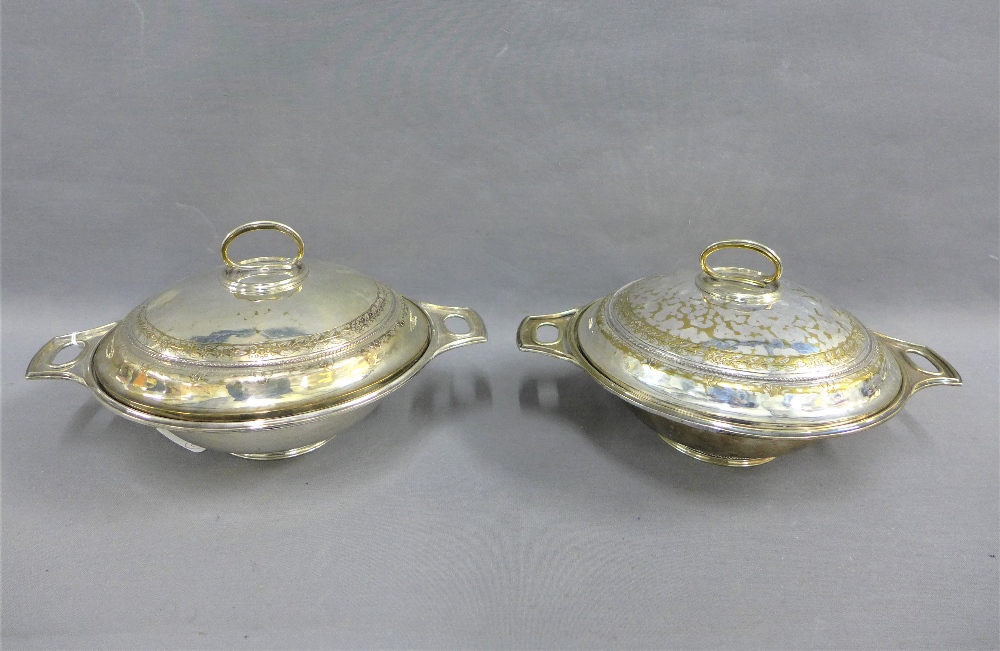 A pair of early 20th century silver plated serving dishes, with hammered finish and domed covers, (