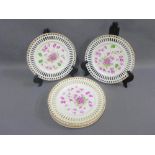 Set of six porcelain plates painted with purple flowers with reticulated rims with gilt edge