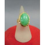 14k gold and jade dress ring set with an oval cabochon to a pierced setting, on plain band,