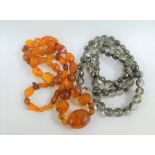 Strand of vintage amber beads with polished oval and facet beads together with a strand of crystal