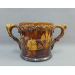 19th century treacle glazed loving cup, possibly Scottish, with a floral moulded rim and with Tavern