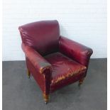 Red leather upholstered armchair on mahogany legs with brass caps and castors, 86 x 80cm
