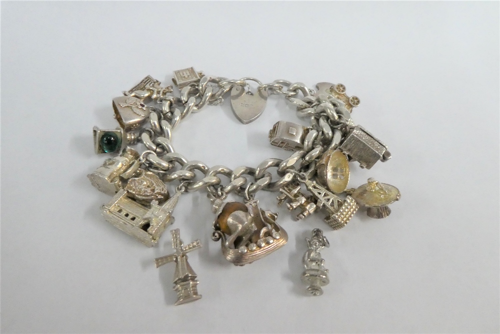 Silver charm bracelet, hung with a quantity of silver and white metal charms, with silver heart