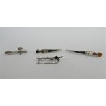 Three silver and hardstone set dagger brooches and a silver golf club brooch (4)