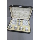 An Aynsley coffee set with six cups and six saucers, the cups with pierced silver holders,