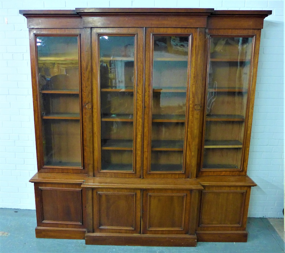 19th century mahogany breakfront bookcase cabinet, the cornice top over four glazed doors with a